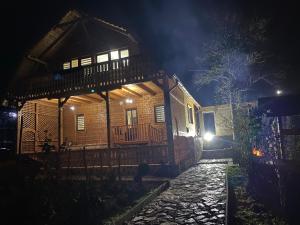 uma casa de madeira à noite com um caminho de pedra em frente em Bob’house em Vulcan