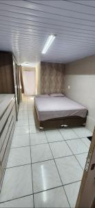 Un dormitorio con una cama y suelo de baldosas. en Casa1, en Itapema