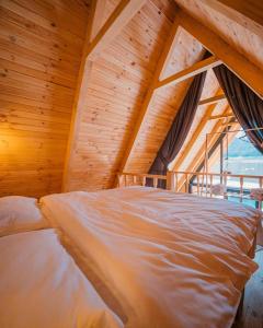 Ce lit se trouve dans un dortoir doté d'un plafond en bois. dans l'établissement peaceful life, 