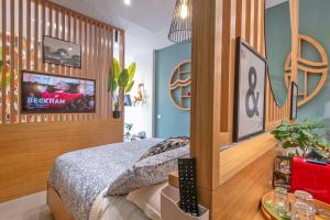 a bedroom with a bed with a tv on the wall at Napoli Suite Station in Naples