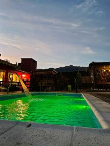 una piscina verde con una fuente de agua en Apart del Valle en Tafí del Valle