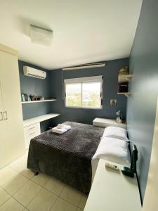 Habitación pequeña con cama y ventana en Apartamento aconchegante em Floripa - caminho das praias, en Florianópolis