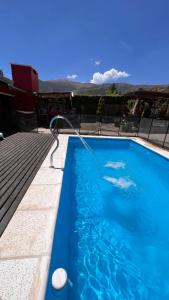 a large blue swimming pool with a hose at Apart del Valle in Tafí del Valle