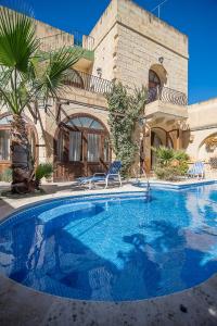 una gran piscina frente a una casa en 4 Bedroom Corner Farmhouse with Private Pool in Zebbug Gozo, en Żebbuġ