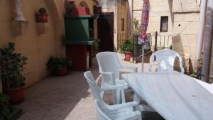 una mesa blanca y sillas en un patio en 4 Bedroom Corner Farmhouse with Private Pool in Zebbug Gozo, en Żebbuġ