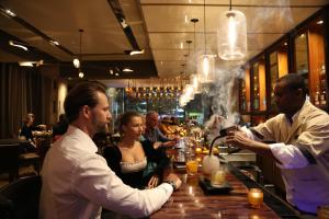 a group of people sitting at a bar at InterContinental New York Times Square by IHG in New York