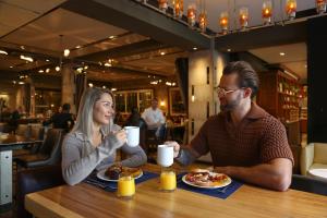 a man and woman sitting at a table eating food at InterContinental New York Times Square by IHG in New York