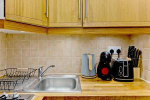 a kitchen counter top with a sink and a counter top at Imperial Earls Court Apartments in London