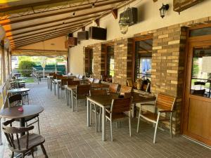 a restaurant with wooden tables and chairs and a brick wall at Izba Vladimír Penzión pod Smrekom in Martin
