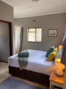 a bedroom with a large bed with pillows on it at Eike Cottage in George