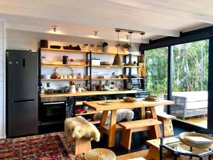 Puerto ClockerにあるCalma Cabinsのキッチン(木製テーブル、冷蔵庫付)