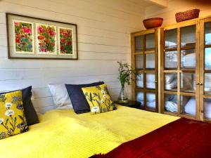 a bedroom with a bed with yellow sheets and pillows at Calma Lodge in Puerto Clocker +91 photos