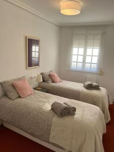 a bedroom with two beds with towels on them at Traviesas in Vigo