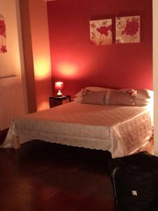 Un dormitorio con una cama con una pared roja. en Appartamento Central Palace Spoleto, en Spoleto