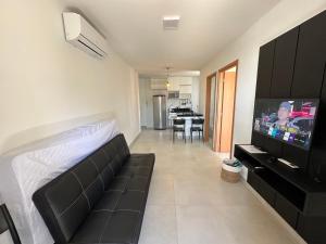 een woonkamer met een bank en een flatscreen-tv bij Studio Design APT 401 Novo na Ponta Verde in Maceió