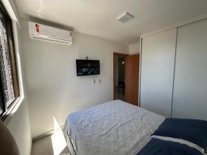 1 dormitorio con 1 cama y TV en la pared en Studio Design APT 401 Novo na Ponta Verde, en Maceió