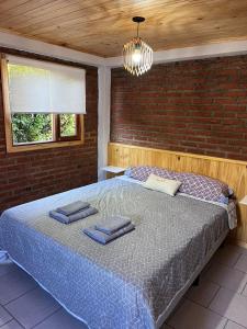 a bedroom with a bed with two pillows on it at Departamentos Centro El Calafate in El Calafate
