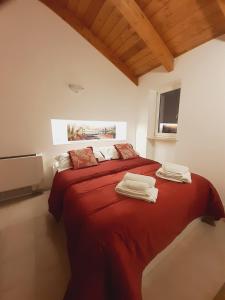 a bedroom with a red bed with towels on it at Casina a Porta Sant'Angelo in Perugia