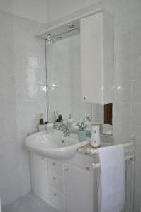 ein weißes Badezimmer mit einem Waschbecken und einem Spiegel in der Unterkunft La Casa di Tommy in Monsagrati