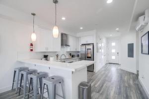 a kitchen with white cabinets and a counter and stools at Park Blvd Paradise 301 ADA compliant with a Spa in San Diego
