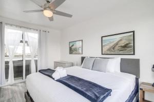 a bedroom with a large white bed with a ceiling fan at Park Blvd Paradise 301 ADA compliant with a Spa in San Diego