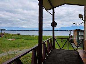 un porche de una casa con vistas al agua en Cabañas Tripanko Chiloe, en Ancud