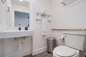 a white bathroom with a toilet and a sink at Park Blvd Paradise 302 ADA compliant with a Spa in San Diego