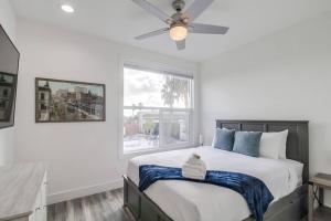 a bedroom with a bed with a ceiling fan and a window at Park Blvd Paradise 302 ADA compliant with a Spa in San Diego