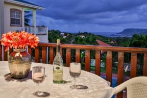 a table with two wine glasses and a vase with flowers at Newly renovated 3-bed spacious family home - Villa Decaj home in Cap Estate
