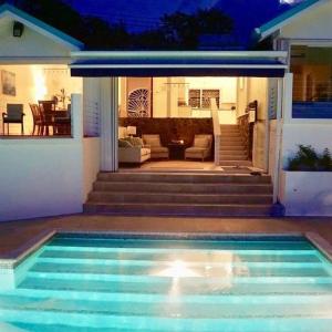 una piscina frente a una casa en La Mer - Bright & Modern 3 bedroom Caribbean Villa villa, en Cap Estate