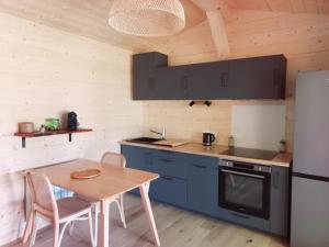 a kitchen with a wooden table and a refrigerator at maisonette et spa bois in La Bégude-de-Mazenc
