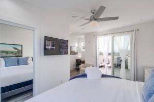 a white bedroom with a bed and a ceiling fan at Park Blvd Paradise 303 king bed With a private Spa in San Diego