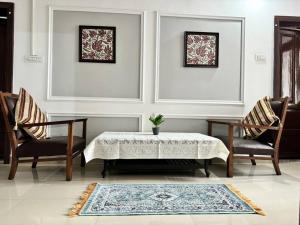 ein Wohnzimmer mit einem Tisch und 2 Stühlen in der Unterkunft Feather Stays - 4 BHK Apartment in a Villa in Srinagar