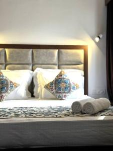 ein Bett mit zwei Kissen und zwei Handtüchern darauf in der Unterkunft Feather Stays - 4 BHK Apartment in a Villa in Srinagar