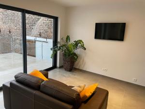a living room with a couch and a flat screen tv at Les Duplex Solaires in Duppigheim