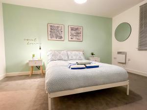 a bedroom with a bed with blue pillows on it at Luxury 2 Bedroom City Centre Apartment - Secure Parking - Amazing location! in Canterbury