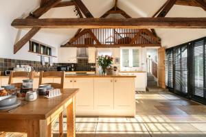 a kitchen with white cabinets and a wooden table at The Cart House in Southampton