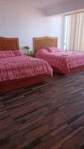 two beds sitting next to each other in a bedroom at Bungalos Las Esperanzas in Cabo Punta Banda