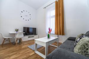 uma sala de estar com um sofá e uma mesa em Cozy apartment in the heart of Prague em Praga