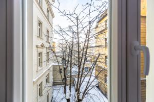 uma janela com vista para uma árvore em frente a um edifício em Cozy apartment in the heart of Prague em Praga