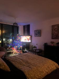 a bedroom with a christmas tree and a television at THE ONE WITH THE PEACEFUL VIBES in London