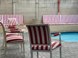 uma fila de cadeiras sentadas ao lado de uma piscina em Durban Italian villa 1&2 em Durban