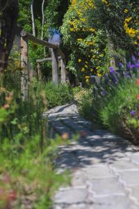 un chemin de jardin avec des fleurs et une clôture en bois dans l'établissement El Carmelo Mountain Lodge, à Potrerillos