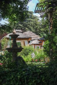 a garden with a fountain in front of a building at El Carmelo Mountain Lodge in Potrerillos