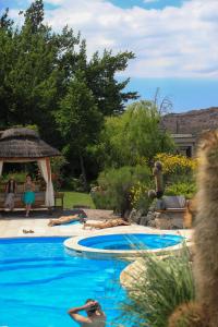 a swimming pool with people laying on the side of it at El Carmelo Mountain Lodge in Potrerillos