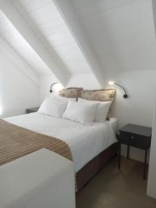 a bedroom with a bed with white sheets and pillows at Spacious loft in Paternoster