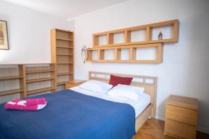 a bedroom with a blue bed with wooden shelves at Central Charm Nowiniarska in Warsaw