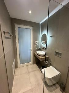 La salle de bains est pourvue de toilettes, d'un lavabo et d'une douche. dans l'établissement MARIKSEL Hotel, à Ksamil