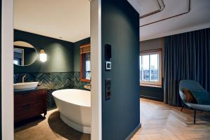 a bathroom with a tub and a sink at Villa Viva - ein Haus das Brunnen baut in Hamburg