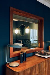 a bathroom with a sink and a mirror at Villa Viva - ein Haus das Brunnen baut in Hamburg